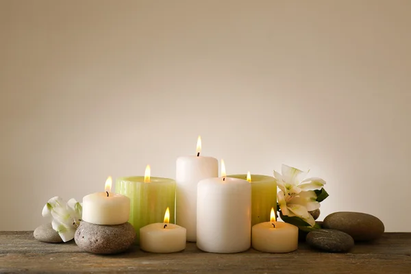 Hermosa composición con velas y piedras de spa sobre fondo claro — Foto de Stock