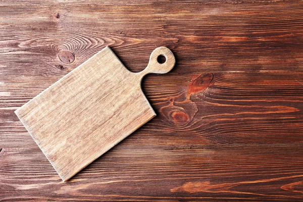 Deska do cięcia na drewnianym tle — Zdjęcie stockowe