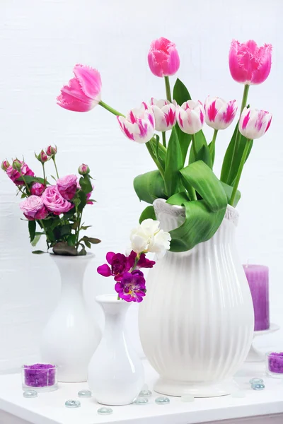 Schöne Komposition mit verschiedenen Blumen in Vasen auf Wandhintergrund — Stockfoto