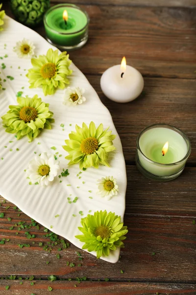 Candles with flowers on plate on table close up — Stock Photo, Image