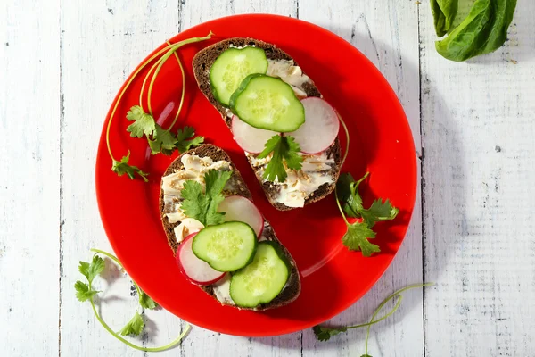 Heerlijke broodjes met groentjes en Groenen op plaat op tafel close-up — Stockfoto