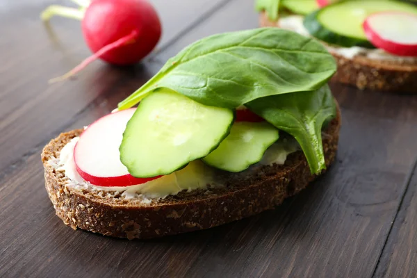 Deliciosos sándwiches con verduras y verduras sobre mesa de madera —  Fotos de Stock