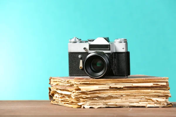 Retro-Kamera mit altem Buch auf Tisch auf grünem Hintergrund — Stockfoto