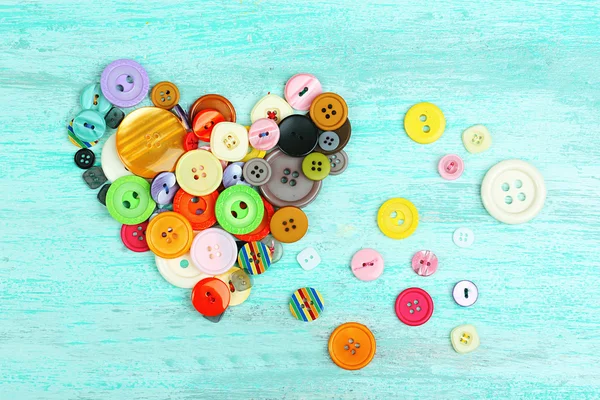Sewing buttons heart on wooden background — Stock Photo, Image