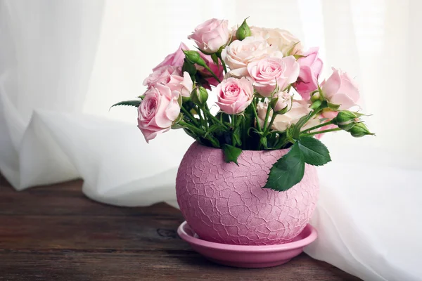 Hermosas rosas en maceta sobre fondo de tela — Foto de Stock