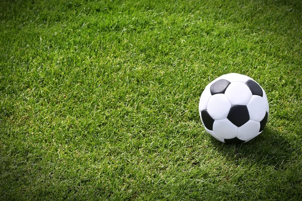 Pelota de fútbol en el campo verde — Foto de Stock