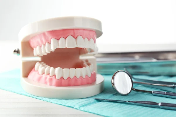 Dientes blancos e instrumentos dentales sobre fondo de mesa —  Fotos de Stock