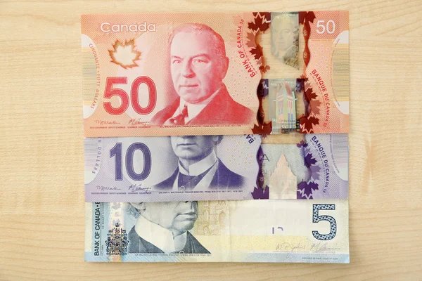 Canadian dollars on wooden table — Stock Photo, Image