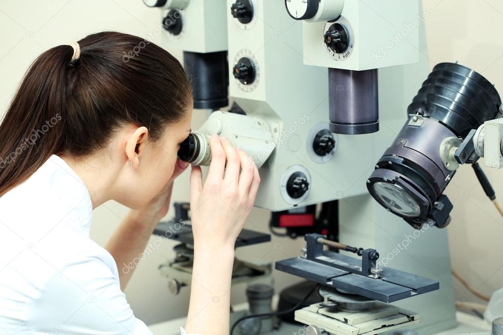 scientist looking through a microscope