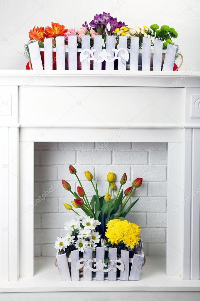 Beautiful flowers in ornamental flowerpot on mantelpiece