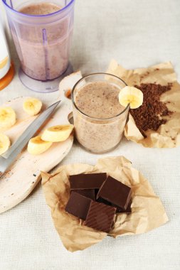 Ahşap arka plan üzerinde muz kesme tahtası ve kıyılmış çikolata, dilimlenmiş