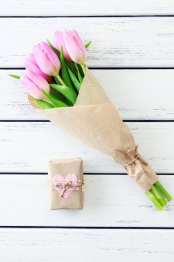 Kağıt ahşap arka plan üzerinde mevcut kutusuyla güzel pembe laleler