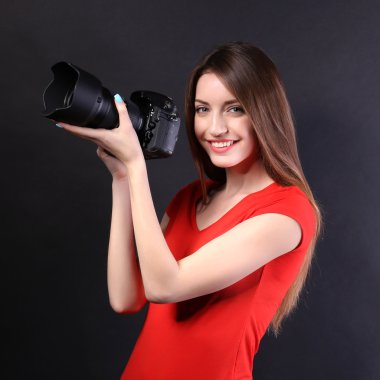 Siyah arka plan üzerine fotoğraf çekmek genç kadın fotoğrafçı