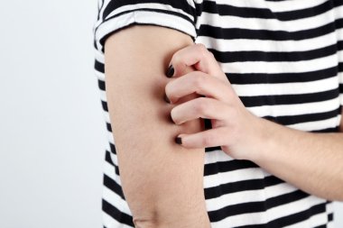 Kadın kaşıntı gri arka plan üzerinde vardır.