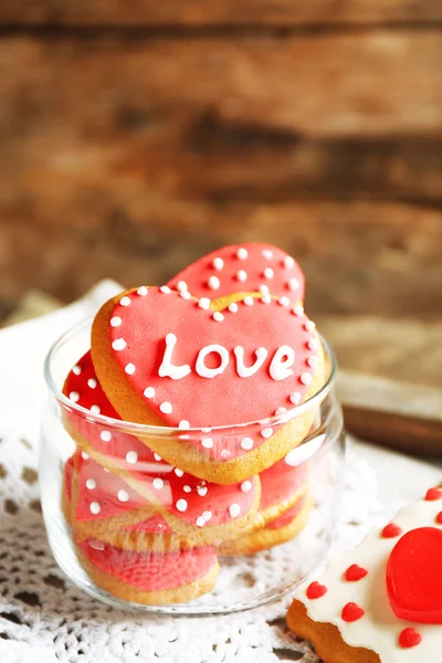 Heart shaped cookies for valentines day in glass jar on color wooden background — Stock Photo, Image