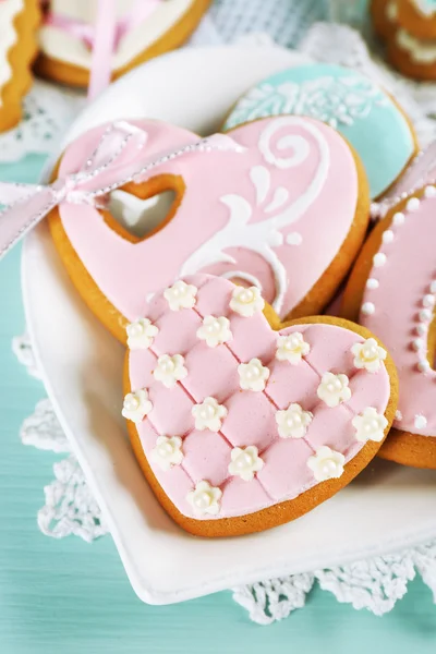 Cookies em forma de coração para dia dos namorados na placa, na cor de fundo de madeira — Fotografia de Stock