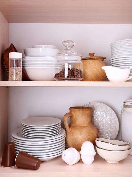 Keukengerei en servies op houten planken — Stockfoto