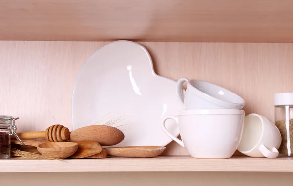 Utensílios de cozinha e utensílios de mesa na prateleira de madeira — Fotografia de Stock