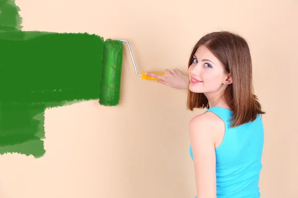 Schönes Mädchen bemalt Wand im Zimmer — Stockfoto