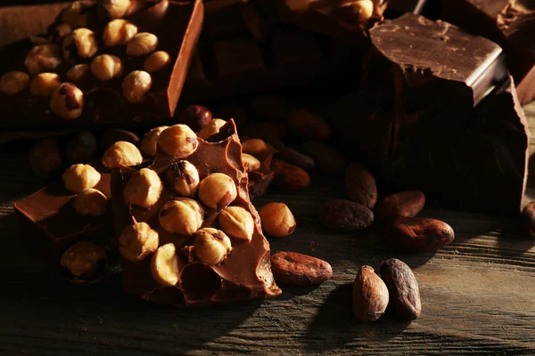 Martwa natura z czekolady z orzechami na drewnianym stole, zbliżenie zestaw — Zdjęcie stockowe