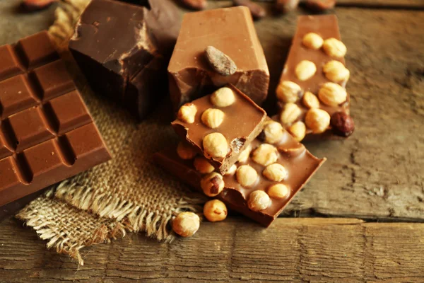 Still life with set of chocolate with nuts on wooden table, closeup — Stock Fotó