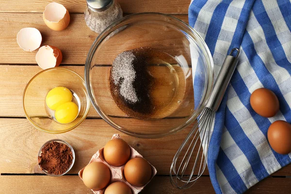 Preparation cream with eggs in glass bowl on wooden background — Stock Photo, Image