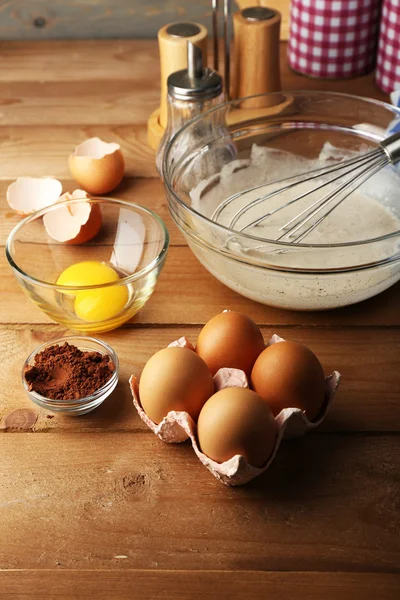 Zubereitungscreme mit Eiern in Glasschale auf Holzgrund — Stockfoto