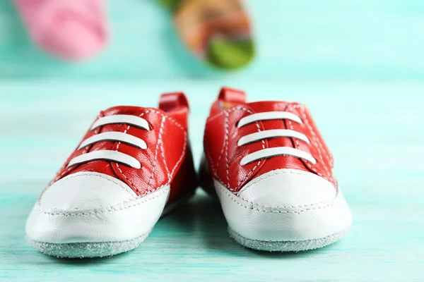 Bunte Kleinkinderschuhe auf hölzernem Hintergrund — Stockfoto