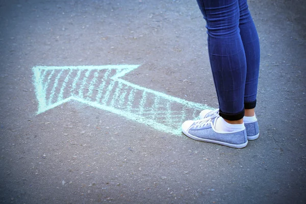 女性の足と舗装の背景に描画の矢印 — ストック写真