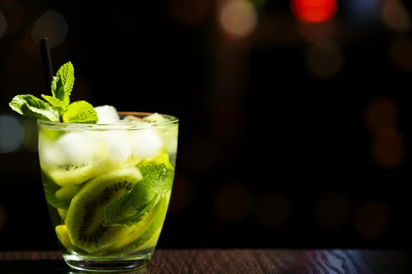 Glass of cocktail in bar on bright blurred background — Stock Photo, Image