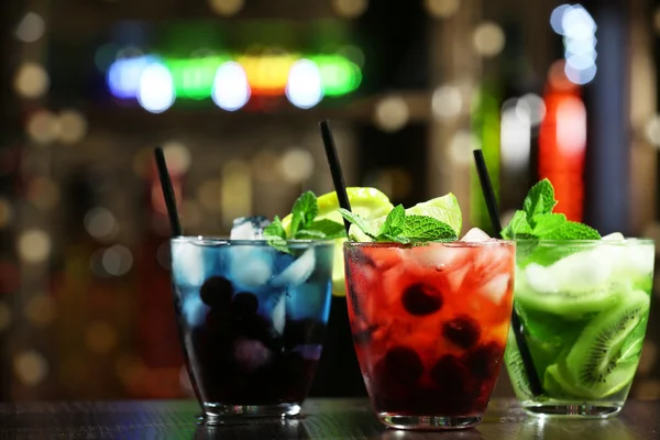 Glasses of cocktails in bar on bright blurred background — Stock Photo, Image