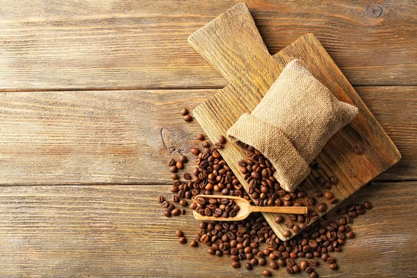 Granos de café sobre fondo de madera — Foto de Stock