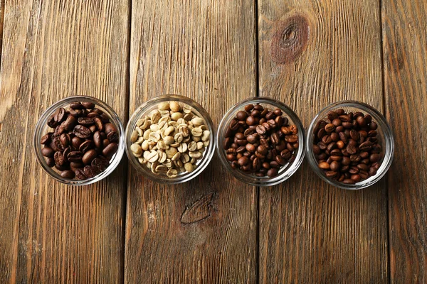 Coffee beans in saucers on wooden background — Stock Photo, Image