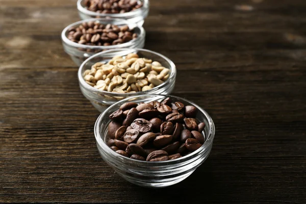 Kaffeebohnen in Untertassen auf Holzgrund — Stockfoto