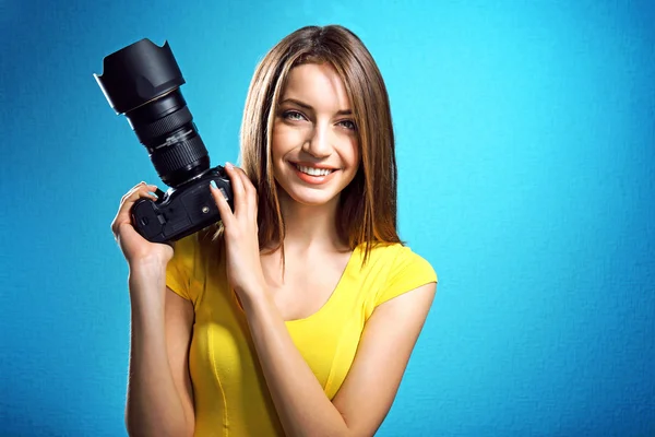 Joven fotógrafa tomando fotos sobre fondo azul —  Fotos de Stock