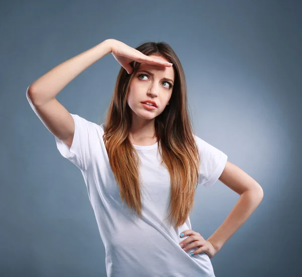 Portret van jonge vrouw op grijze achtergrond — Stockfoto