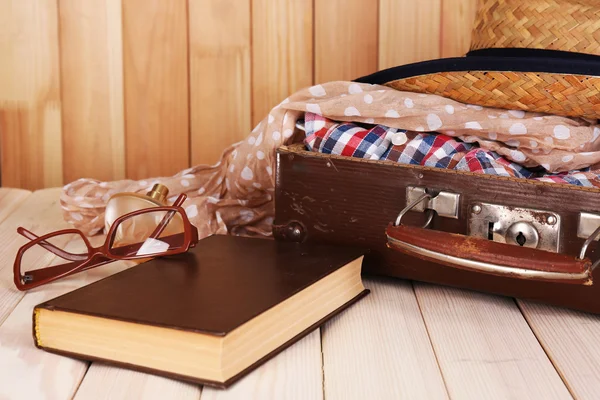 Csomagolás a suitcase utazás a fából készült háttér — Stock Fotó