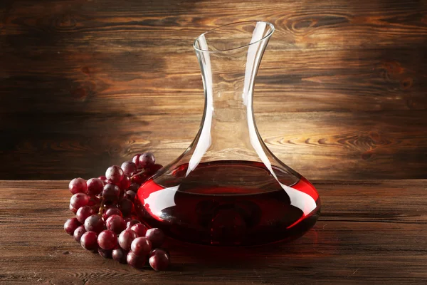 Glass carafe of wine on wooden background — Stock Photo, Image