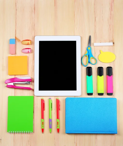 Digital tablet with stationery on wooden background — Stock Photo, Image