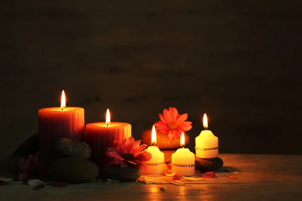 Hermosa composición con velas y piedras de spa sobre fondo de madera — Foto de Stock