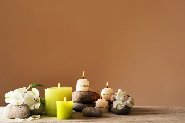 Hermosa composición con velas y piedras de spa sobre fondo claro — Foto de Stock