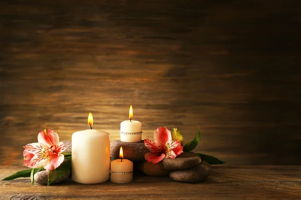 Hermosa composición con velas y piedras de spa sobre fondo de madera —  Fotos de Stock