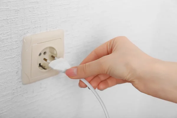 Mão colocando plug-in tomada de eletricidade de perto — Fotografia de Stock