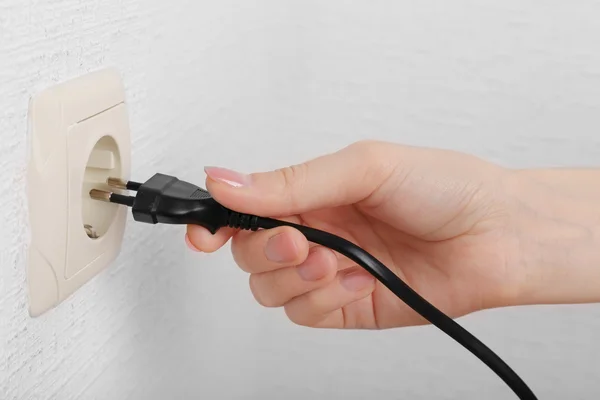 Mão colocando plug-in tomada de eletricidade de perto — Fotografia de Stock