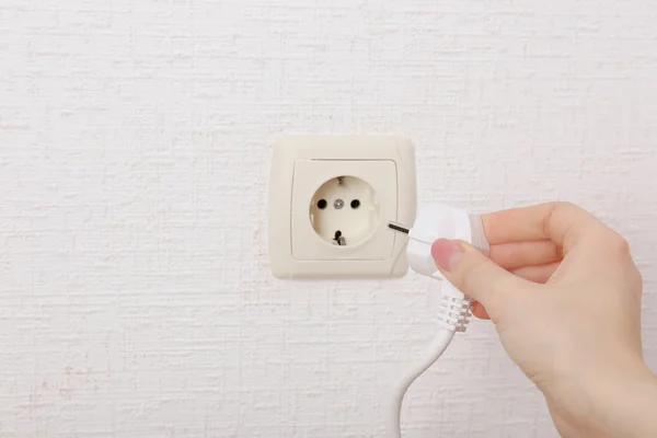 Hand putting plug in electricity socket close up — Stock Photo, Image