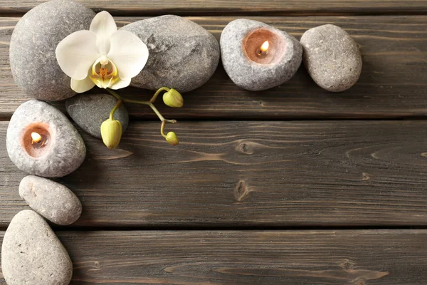 Spa stones and orchid flower on wooden background — Stock Photo, Image