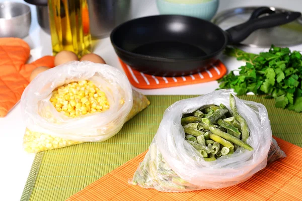 Frozen vegetables in bags on kitchen table close up — Stock Photo, Image