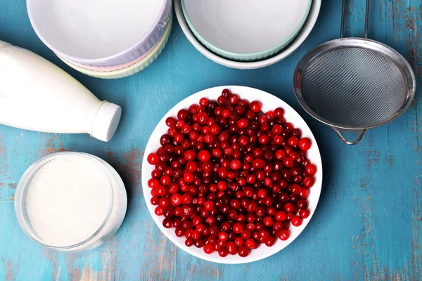 Canneberges dans un bol avec du lait et du sucre sur la table de cuisine fermer — Photo