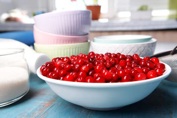 Cranberries in bowl with milk and sugar on kitchen table close up — Stock Photo, Image