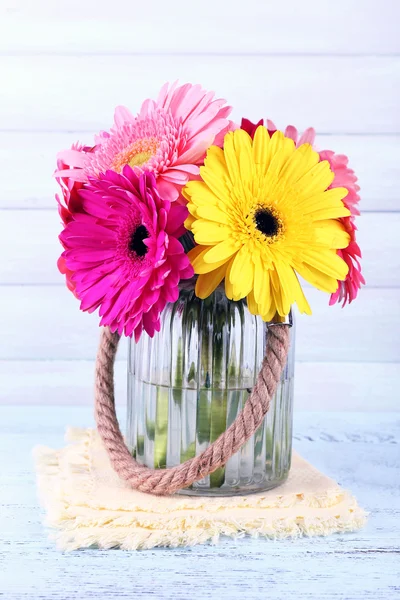 Beautiful bright gerberas in vase on wooden background — Stock Photo, Image